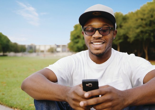 African American man in park using cell phone
